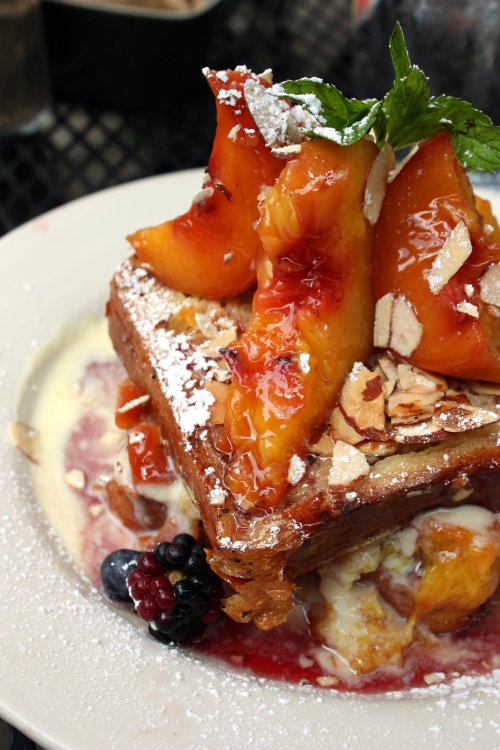 Summer peach & almond bostock french toast: Two thick slices of home made almond crusted brioche french toast, layered with warm syrah poached summer peaches and vanilla creme anglaise.